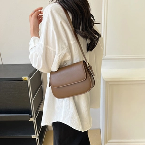 Detail van de minimalistische donkerbruine leren crossbodytas met verstelbare schouderriem