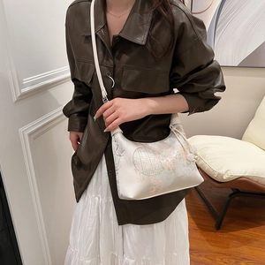 Close-up of New Chinese style ivory silk dumpling bag with floral and bird embroidery