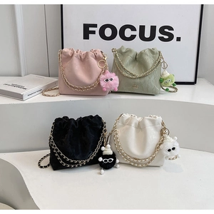 Detail of four colorful drawstring bucket bags with chain straps and plush charms