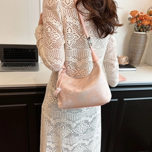 Detail of pink jacquard shoulder bag featuring traditional landscape texture and drawstring