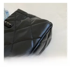 Close-up of diamond quilted black leather and precision stitching on chain bag