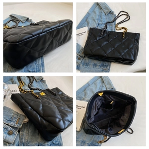 Detail view of large quilted tote bag with gold chain strap and interior zip pocket