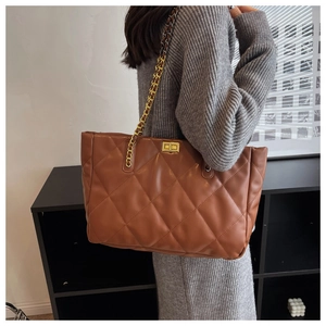 Detail shot of brown quilted tote bag with gold chain strap and elegant turn-lock closure