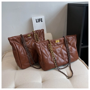 Detail of brown quilted leather tote bags featuring diamond stitching and metal chain straps