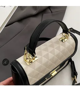 Detail of comfortable black leather handle and triangle embossed texture on a cream bag