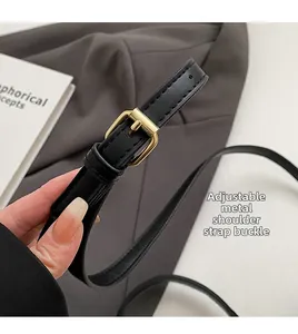 Close-up of adjustable black leather shoulder strap with premium golden metal buckle