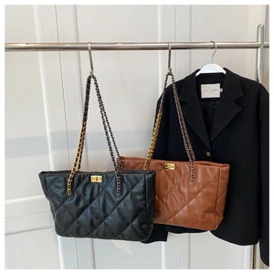 Detail of large quilted tote bags in black and brown with gold chain and turn-lock