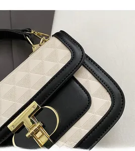 Detailed close-up of contrast leather texture with triangle embossing and golden lock
