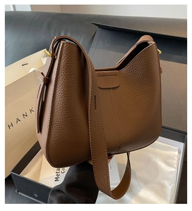 Detailed macro of brown lychee grain leather hobo bag inside a premium gift box