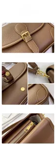 Close-up of brown litchi pattern leather bag with gold buckle and metal hardware details