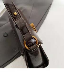 Detail of vintage brown crinkled leather texture and retro gold metal ring hardware