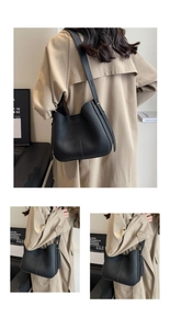 Close-up of black lychee grain leather handbag with adjustable wide strap and curved opening