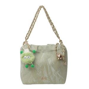 Mint green drawstring bucket bag with gold chain strap and plush monster charm