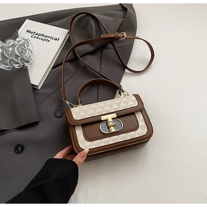 Detail of the geometric embossed flap and golden metallic twist lock on the brown bag