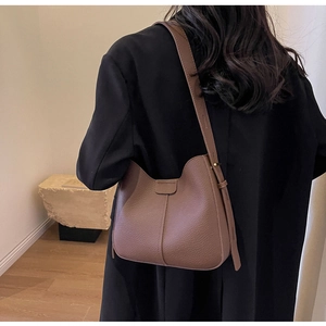 Detail of a brown lychee pattern leather Hobo bag with adjustable shoulder strap and stitching