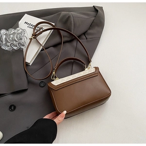 Detail of brown and cream quilted leather handbag with gold-tone hardware and strap