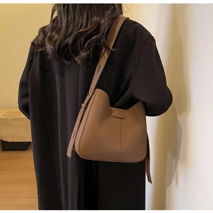 Detailed close-up of brown pebbled leather texture on a hobo shoulder bag