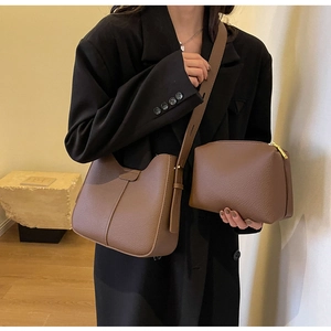 Detail shot of coffee brown lychee textured leather tote set with an adjustable shoulder strap