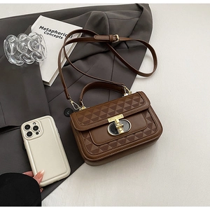 Detail showing brown leather handbag with embossed triangle texture and gold T-lock