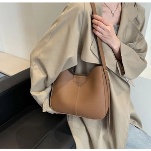 Detail of caramel brown litchi grain leather shoulder bag with adjustable strap