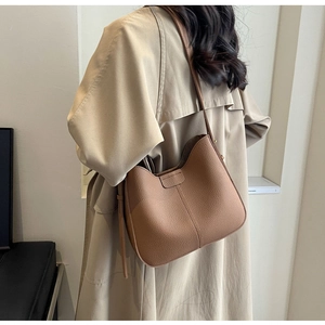 Detail of lychee pattern leather shoulder bag showing texture and side strap fixing