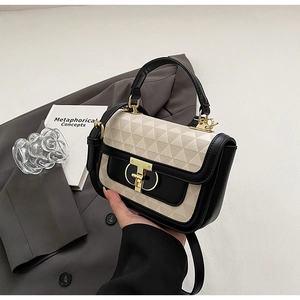 Detail of geometric embossed texture on contrast color crossbody bag with gold lock