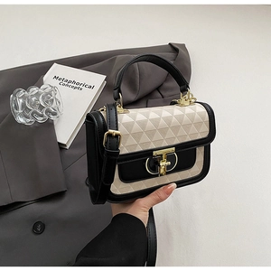 Detail of a chic square bag with beige triangular texture and golden T-ring clasp closure