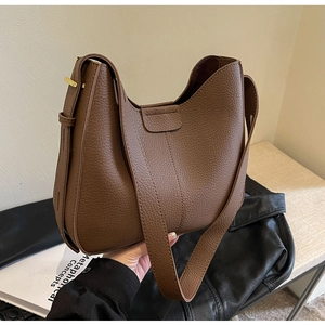 Detail of brown lychee grain leather Hobo bag with wide strap and gold metal buckle
