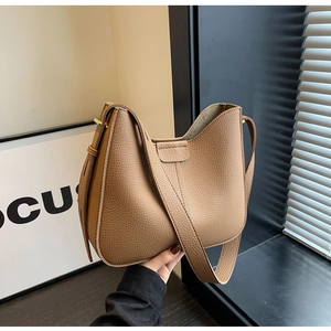 Detail view of the brown lychee pattern leather texture and adjustable shoulder strap