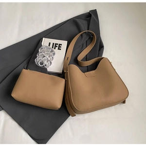 Detailed macro view of khaki lychee grain leather tote with matching inner pouch