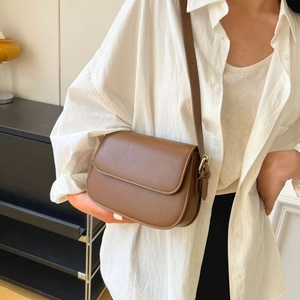 Minimalistische donkerbruine lederen crossbodytas met verstelbare riem en metalen gesp