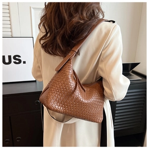 Borsa hobo marrone in pelle intrecciata su un blazer beige per un look elegante e sobrio