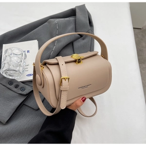 Detail of beige leather crossbody bag featuring gold hardware and elegant buckle