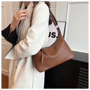 Dettaglio della trama intrecciata marrone di una borsa hobo con zip e tracolla in pelle