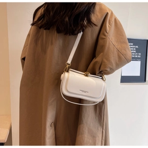 Detail of white leather crossbody bag with golden metal buckle and fashion logo
