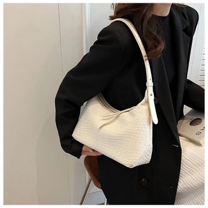 Borsa hobo bianca intrecciata abbinata a blazer nero e gonna bianca per l'ufficio