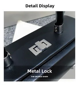 Detail of a black leather handbag featuring a polished silver metal twist lock closure