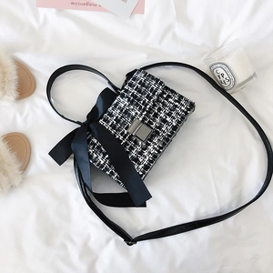 Sac bandoulière élégant en tweed noir et blanc avec nœud décoratif et fermoir métal