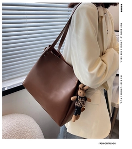 Deep brown tote bag detail with cute bunny charm and houndstooth vest accessory