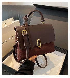 Close-up of retro burgundy suede handbag with gold clasp in a premium gift box