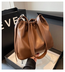 Detailed shot of brown pleated leather cloud bag with drawstring and long strap