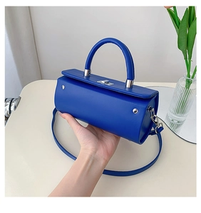 Détail du sac boîte cylindrique bleu avec fermoir argenté et finition en cuir lisse