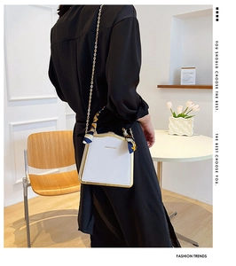 White box bag with gold metal frame, chain strap, and scarf-wrapped handle detail