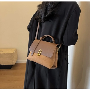 Detail of retro contrast leather handbag with gold U-buckle and adjustable strap