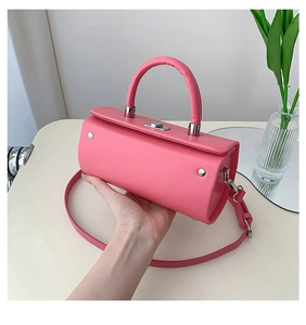 Détail du sac à main cylindrique rose avec fermoir rotatif argenté et texture en cuir