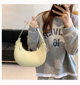 Close-up of a minimalist creamy yellow crescent PU leather underarm bag for women
