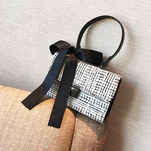 Mini sac à main en tweed noir et blanc avec fermoir en métal argenté et nœud en satin