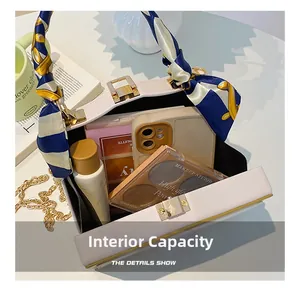 Detail view of white box bag interior showing capacity for phone and cosmetics
