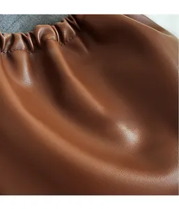 Detailed macro view of soft dark brown pleated leather with refined drawstring texture