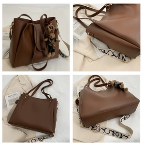 Detail of brown leather tote bag featuring bohemian strap and cute rabbit pendant